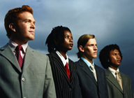 Cuatro trabajadores con chaqueta y corbata mirando al horizonte.