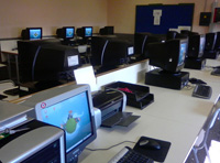 Imagen que muestra una sala de ordenadores. Éstos están encendidos y no hay nadie en la sala en ese momento. 