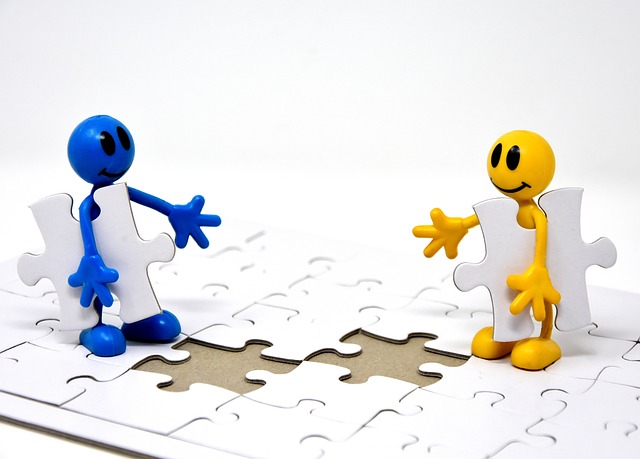 Puzzle Dos muñecos encajando piezas en puzzle.