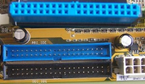 Muestra dos conectores de tipo IDE; el primario y el secundario. Y un cable con conector preparado para su inserción.