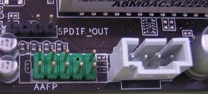 Se muestra un grupo de pines que salen de la placa base, en los que deben insertarse los cables que vienen del frontal para conectar micrófono y altavoces. Y un conector de entrada a la tarjeta de sonido integrada.    