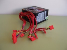 Vista de una fuente de alimentación de la que salen sus cables con sus conectores.