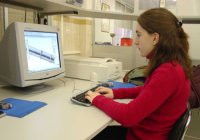 Persona trabajando con un ordenador con varios periféricos de E/S